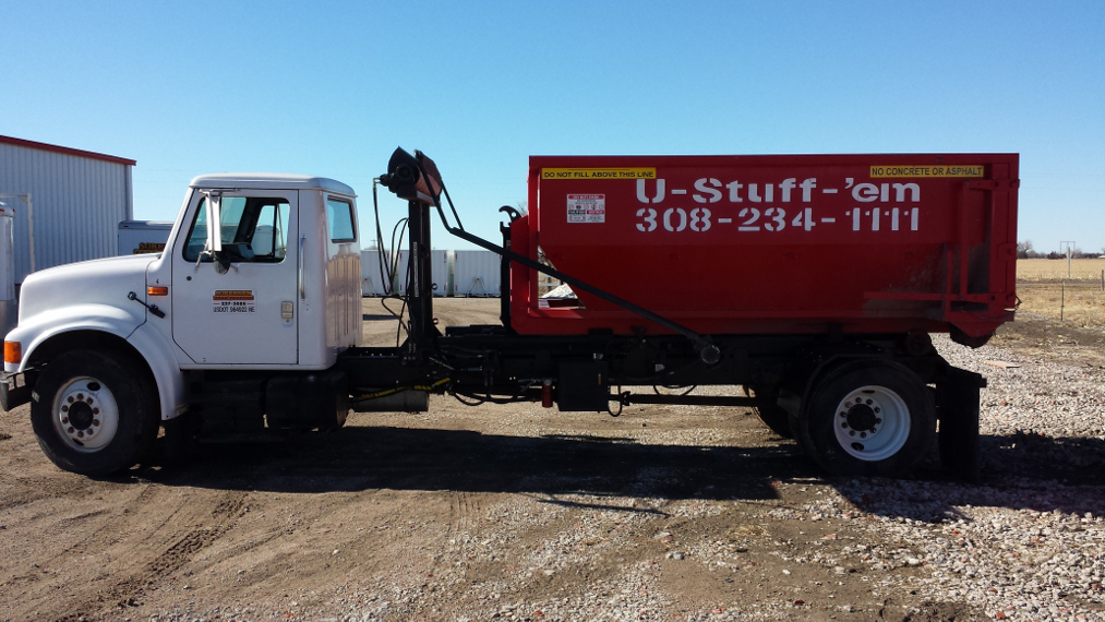 U-Stuff-'em truck with a red roll-off dumpster